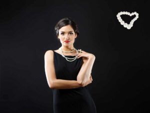 Donna con collana di perle e vestito nero