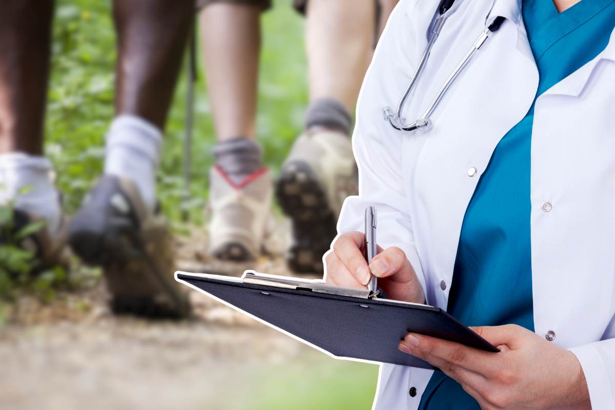 persone che camminano sullo sfondo e medico che scrive sulla cartella