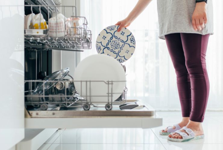 donna che mette piatti in lavastoviglie