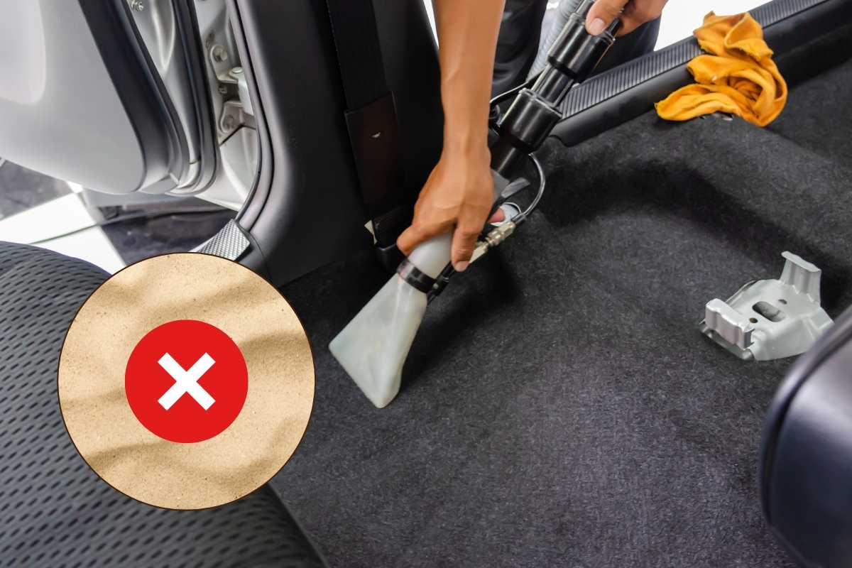 Persona pulisce auto, sabbia con croce
