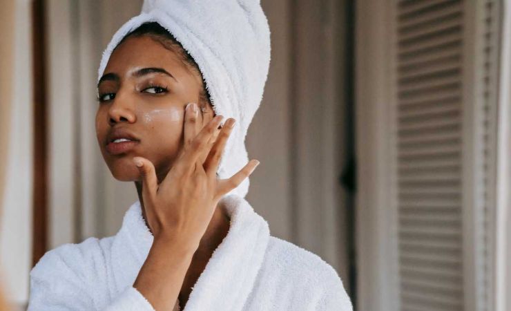 donna che mette crema in viso
